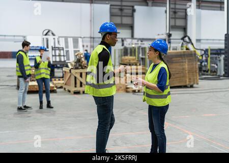 Team of multiracial engineers working in robotic factory - Tech industry concept Stock Photo