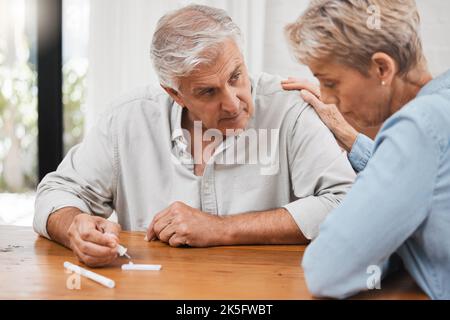 Covid, test and stress with a senior couple using a rapid antigen kit at home with anxiety about the results. Fear, worry and healthcare with an Stock Photo