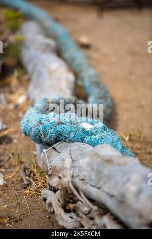 old worn ropes on a harbour wall, blue ropes, white man made ropes, frayed shipping ropes, discarded fishing ropes on the harbour side in portsmouth Stock Photo