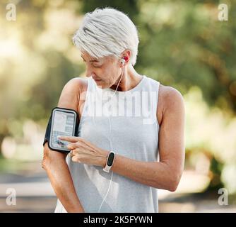 Senior woman with phone running app for steps, fitness and training exercise tracking while on run, walk or cardio workout. Retirement lifestyle Stock Photo