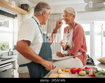 Champagne, cooking and senior couple in kitchen celebrate retirement with healthy food, vegetables or salad for vegan lifestyle. Celebrate, luxury and Stock Photo