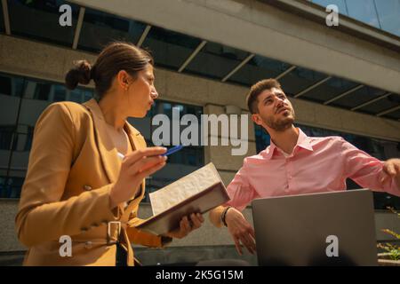 A young talented business people are working outside in the city, on a sunny day Stock Photo