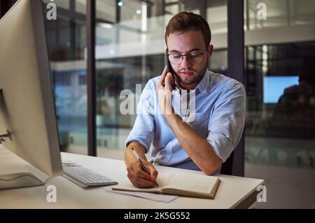 Businessman, phone call at night and writing in notebook for planning, schedule or agenda for business meeting in office. Corporate worker in Stock Photo