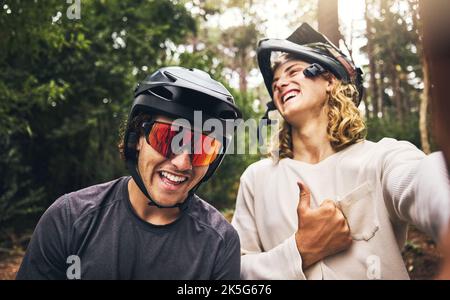 Friends, cycling men and selfie in forest, park or woods cyclist trail in nature. Thumbs up, fitness and cyclists, bikers or bike rider smile in Stock Photo