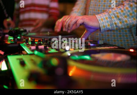 Hip hop dj scratches records and plays music on hip hop party in nightclub. Professional disc jokey mixing records on turntables. Disk jockey scratchi Stock Photo