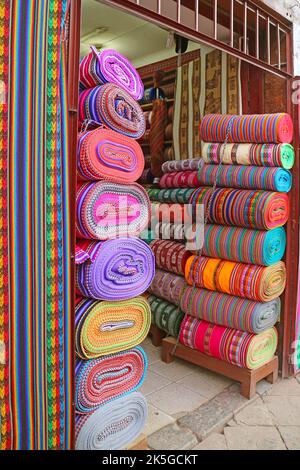 Stacks of Amazing Multi-colored Peruvian fabric rolls for sale in downtown Cuzco, Peru, South America Stock Photo