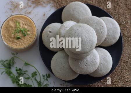Kodo millet idly. Steamed savory cakes made of kodo millets and lentil flour, served with spiced coconut condiment. Kodo millet is used as healthy mil Stock Photo