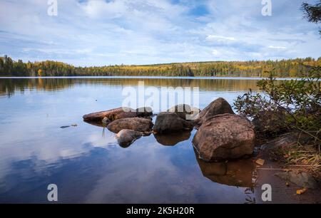Low angle view of a calm lake with rocks in northern Minnesota on a beautiful autumn day Stock Photo