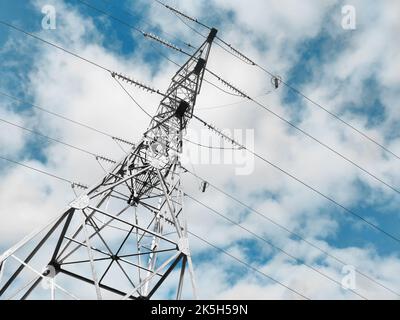 Tower of Electrical power lines on blue cloudy sky background Stock Photo