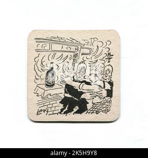 A vintage beer mat promoting the English beer, Newcastle Brown Ale. Decorated with an amusing cartoon image by Terence ‘Larry’ Parkes depicting a man wrestling with firemen, attempting to rescue his bottle of beer from a house fire. Likely to date from the 1970s or 1980s. Stock Photo