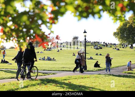 London, UK 8th October 2022. Primrose Hill in north London busy with people enjoying the mini-heatwave and autumn colours. While not quite sunbathing weather, you might be able to hold off from switching on the heating for a bit longer. Credit: Monica Wells/Alamy Live News Stock Photo