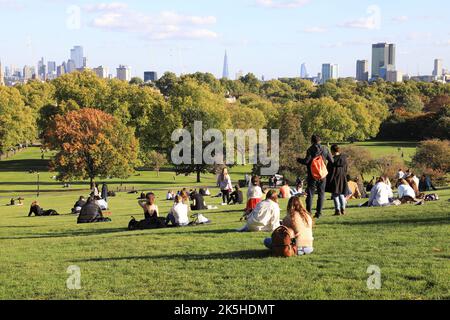 London, UK 8th October 2022. Primrose Hill in north London busy with people enjoying the mini-heatwave and autumn colours. While not quite sunbathing weather, you might be able to hold off from switching on the heating for a bit longer. Credit: Monica Wells/Alamy Live News Stock Photo