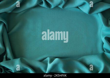 Abstract linen blend wavy fabric texture background. Crumpled green hue dyed linen textiles canvas background. Top view Stock Photo