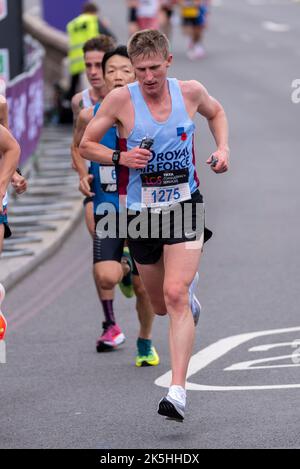Simon Birch in Royal Air Force vest club runner running in the TCS London Marathon 2022 road race in Tower Hill, City of London, UK. Stock Photo