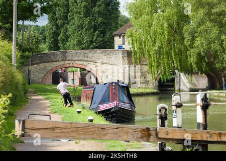 NORTHAMPTONSHIRE, UK - May 25, 2022. Man mooring narrowboat on a canal at Stoke Bruerne, a historic village on the Grand Union Canal Stock Photo
