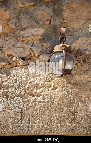 rusty old decorative lantern hanging on a stone wall. Stock Photo