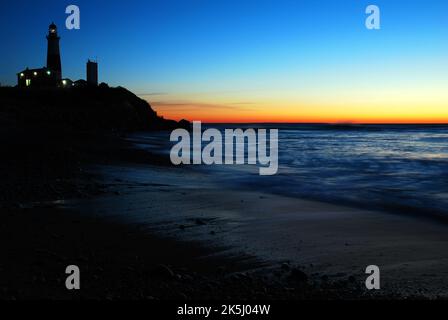Dawn breaks over the Atlantic Ocean and renders the Montauk Point Lighthouse, at the easternmost tip of Long Island in silhouette Stock Photo