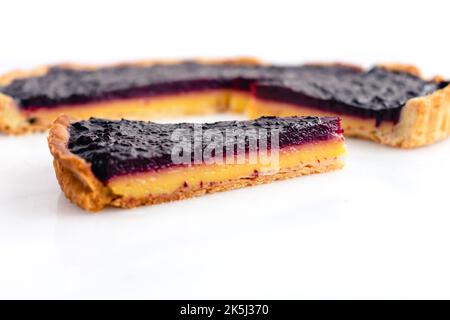 Sliced Blueberry–Lemon Curd Tart Viewed from the Side: Layered blueberry-lemon tart on a white marble background Stock Photo