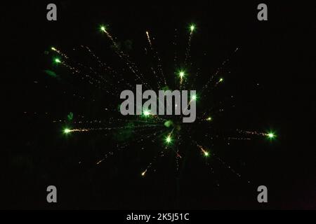 New Year's Eve fireworks night sky with yellow and green sparks Stock Photo