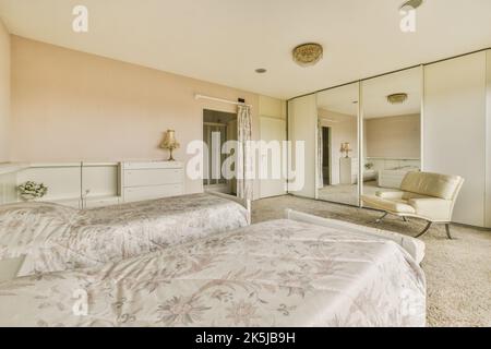 Interior of light bedroom with queen size bed and classic armchair against big windows Stock Photo