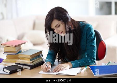 Shes a focused student. Attractive young student sitting at a desk and studying. Stock Photo