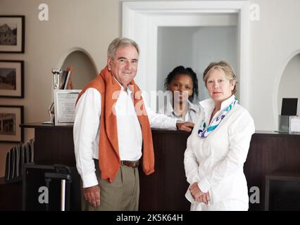 Enjoying friendly, professional service. A senior couple checking in at the reception desk of their hotel. Stock Photo