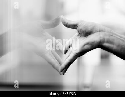 The reflective touch. A hand pressed against a window with itamp039s reflection in the glass. Stock Photo