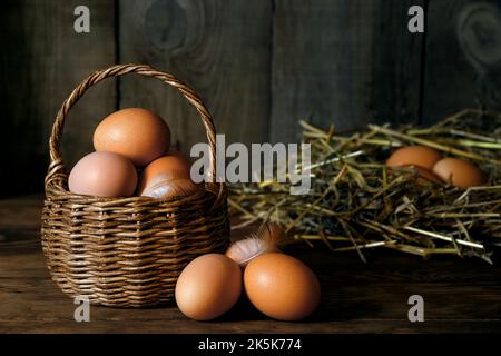 chicken eggs in wicker basket and in nest Stock Photo