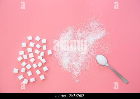Scattered sugar and sugar cubes on a pink background, flat lay. Stock Photo