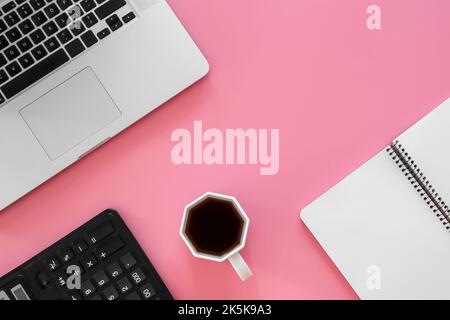 Office background with coffee, laptop on pink background. Stock Photo