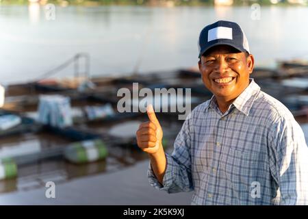 Asian happy aquaculture farmers at ponds and cages. Tilapia Farming. Tilapia fish. Stock Photo