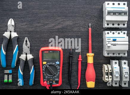 Different electrical tools on wooden background, flat lay. Stock Photo