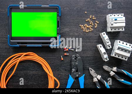 Different electrical tools and digital tablet on wooden background, flat lay. Stock Photo