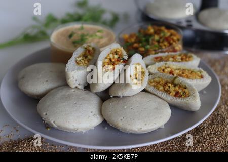 Paneer stuffed kodo millet Idly. Steamed savory cakes made of kodo millets and lentil flour stuffed with a patty made of scrambled cottage cheese with Stock Photo
