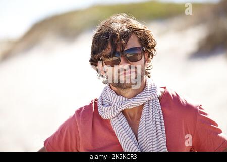 Hes got an adventurous soul. A young man wearing glasses and a scarf looking directly at the camera. Stock Photo