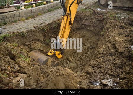 A road excavator dredges the hole near the family house Stock Photo