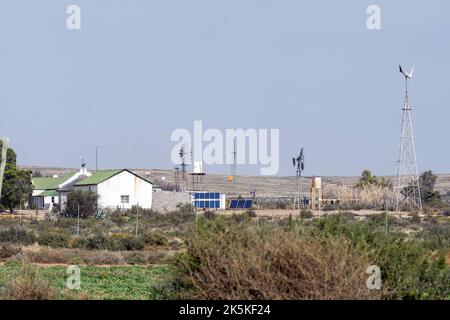 LOXTON, SOUTH AFRICA - SEP 2, 2022: Solar and wind power generation on a farm near Loxton in the Northern Cape Karoo. A house and windmills are visibl Stock Photo