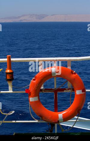 View of a lifebuoy with self igniting light fitted on the guardrails of a merchant ship at sea Stock Photo