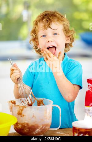 The future of the culinary arts. A little boy covered in dough and flour. Stock Photo