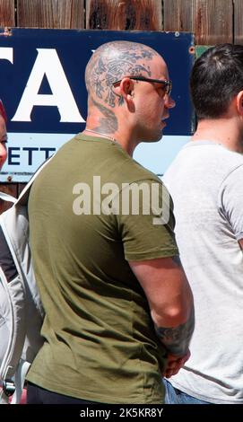 young man with shaved bald head covered in tattoos Stock Photo