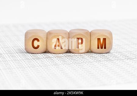 Business concept. On the table with documents are wooden cubes with the inscription - CAPM Stock Photo