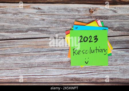 New year 2023 goals, resolutions and bucket list concept. Colorful sticky notes on wood background. Stock Photo