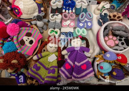 Attractive mix of hand knitted novelties and hats for sale in the Royal Oak pub Laxfield in Suffolk Stock Photo