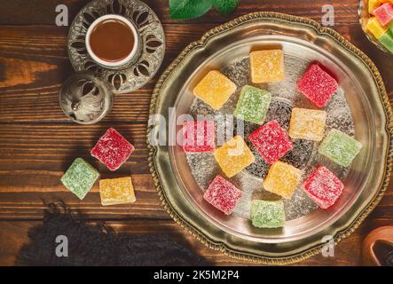 Turkish coffee cup placed with roasted coffee beans and Turkish delights on rustic wooden background. Top view with copy space. Stock Photo