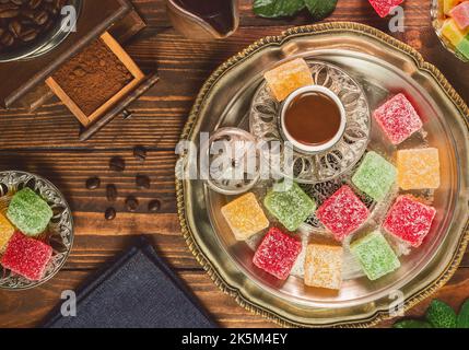 Turkish coffee cup placed with roasted coffee beans and Turkish delights on rustic wooden background. Top view with copy space. Stock Photo