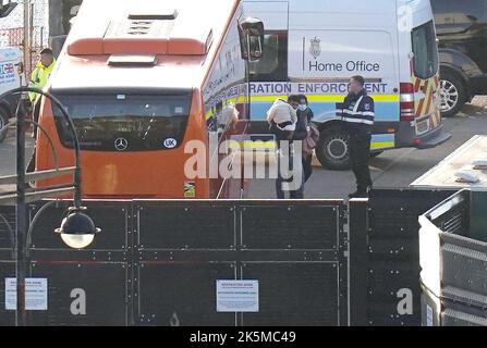 A man carries a young child as a group of people thought to be migrants walk through the Border Force compound in Dover, Kent, after being brought from a Border Force vessel following a small boat incident in the Channel. Picture date: Sunday October 9, 2022. Stock Photo