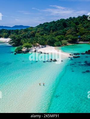 Koh Kham Trat Thailand, aerial view of the tropical island near Koh Mak Thailand. white sandy beach with palm trees and big black boulder stones in the ocean view from drone