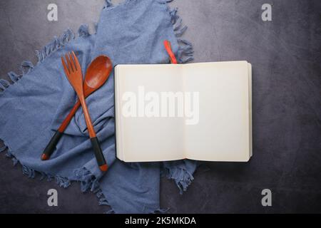open notepad and wooden spoon on table cloth  Stock Photo