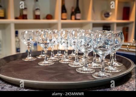 Close up empty white plates stacked on each other and wine glasses on restaurant table Stock Photo