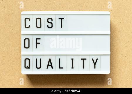 Lightbox with word cost of quality on wood background Stock Photo